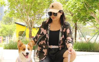 Dog mom outdoors with a Corgi wearing a small dog harness and leash