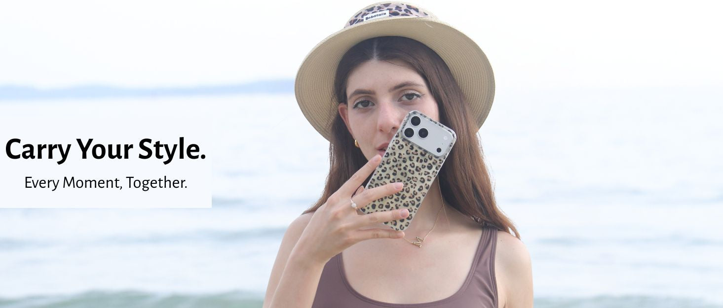 A woman wearing bobotails leopard sun hat and a brown tank top takes a mirror selfie with a leopard-print phone case against an ocean background. Text on the left reads 'Carry Your Style.