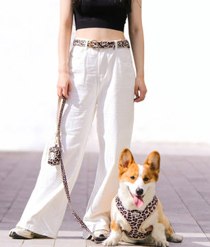 Woman walking her dog wearing leopard print matching dog and owner accessories designed as one coordinated system