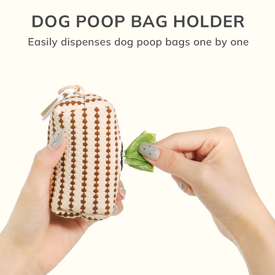 Bobotails  small grain dog poop bag holder pouch is shown with two hands against a light cream background. One hand holds the pouch, and the other holds a green dog poop bag.